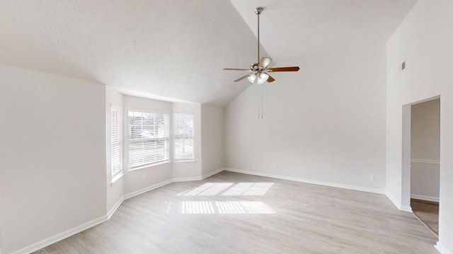 spare room featuring a textured ceiling, light wood-style flooring, baseboards, and ceiling fan