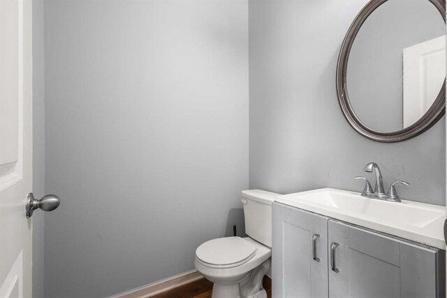 bathroom with toilet, vanity, and baseboards