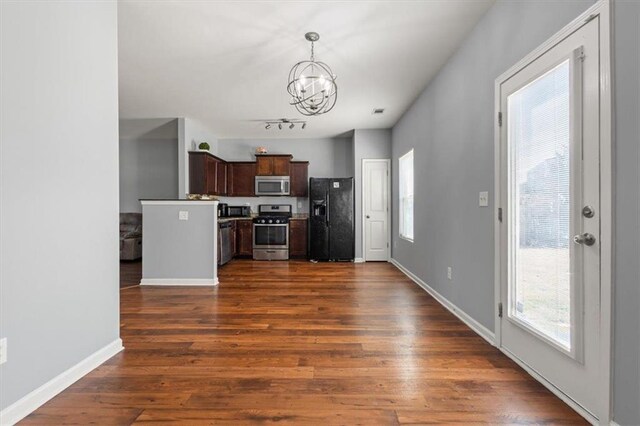 kitchen with a notable chandelier, dark wood-style flooring, stainless steel appliances, baseboards, and dark brown cabinets