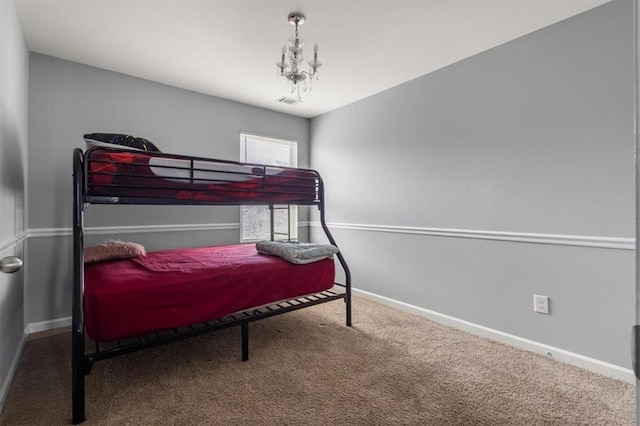 carpeted bedroom featuring a notable chandelier