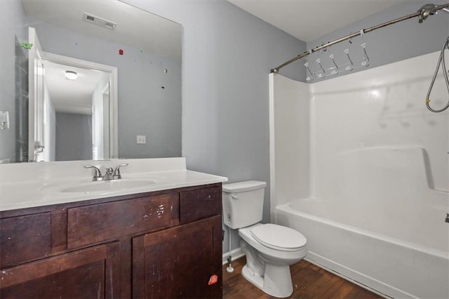 bathroom featuring vanity, shower / bath combination, toilet, visible vents, and wood finished floors