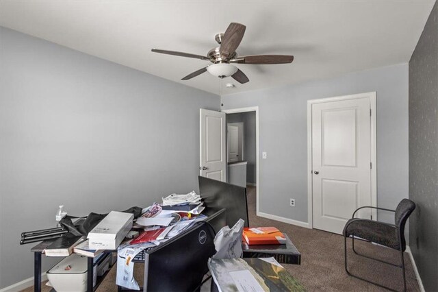 carpeted home office featuring baseboards and a ceiling fan
