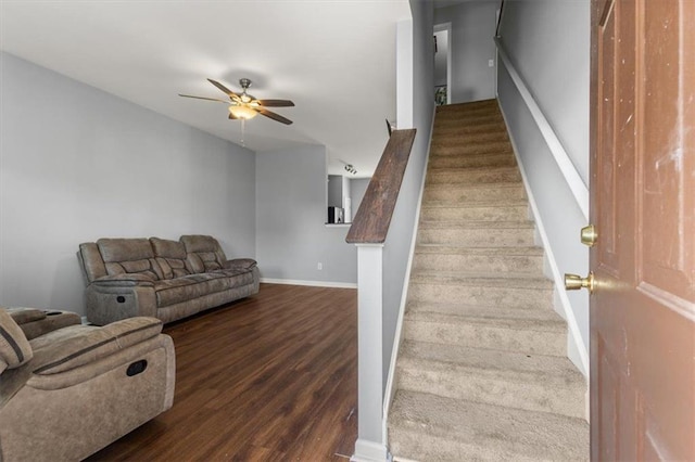 stairs featuring baseboards, wood finished floors, and a ceiling fan