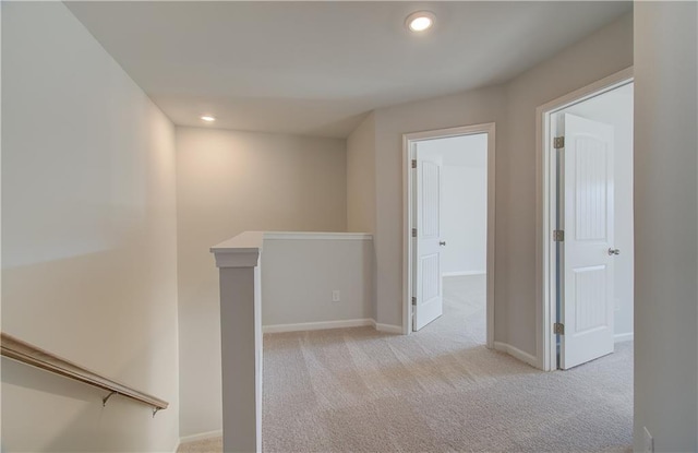 hallway featuring recessed lighting, carpet, baseboards, and an upstairs landing