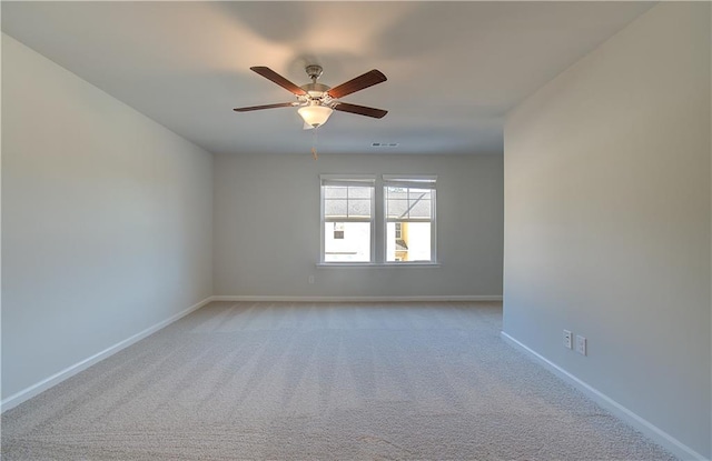 empty room featuring a ceiling fan, light carpet, visible vents, and baseboards