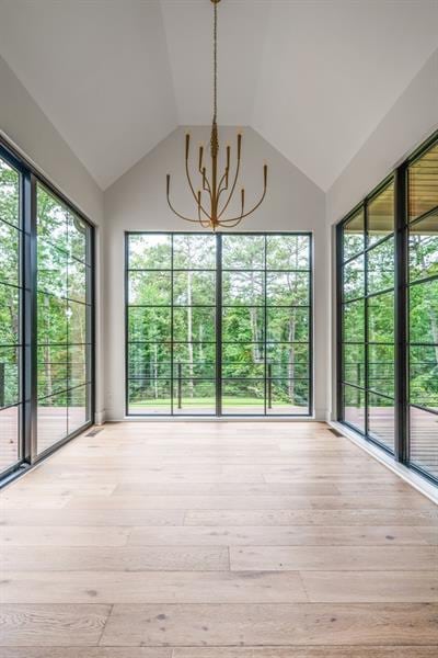 unfurnished sunroom featuring an inviting chandelier and a healthy amount of sunlight