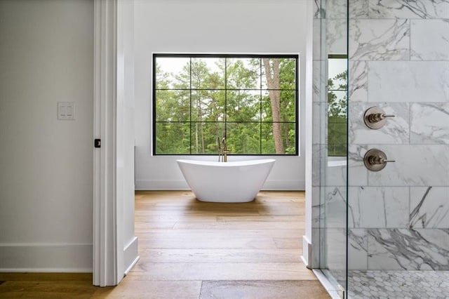 bathroom with hardwood / wood-style floors and separate shower and tub