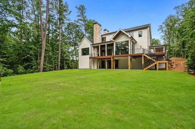 back of house with a lawn, a sunroom, and a deck