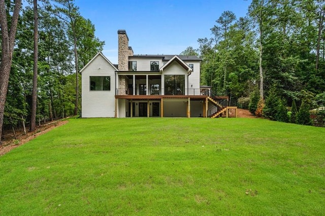 back of property with a sunroom, a yard, and a deck