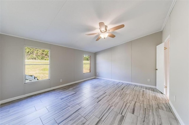 empty room featuring crown molding, light wood-type flooring, and ceiling fan