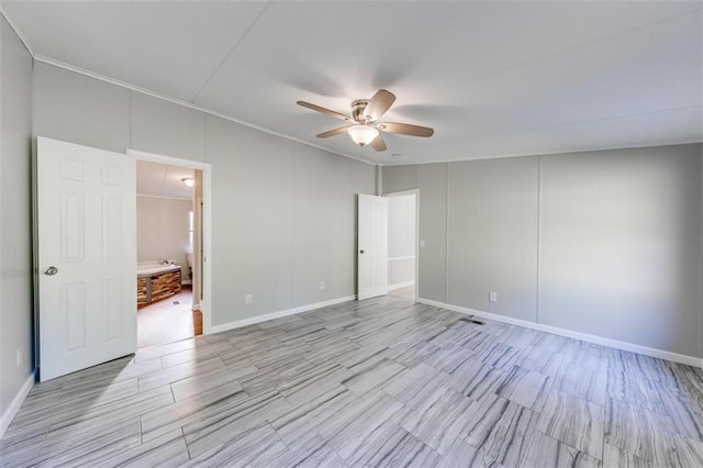 spare room featuring crown molding, light wood-type flooring, and ceiling fan