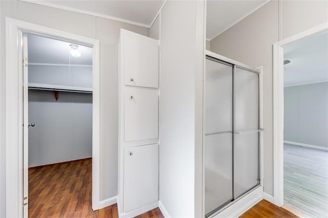 bathroom with an enclosed shower and hardwood / wood-style floors