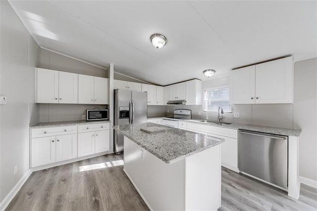 kitchen with white cabinetry, a center island, stainless steel appliances, and lofted ceiling