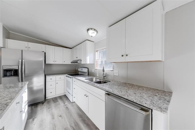 kitchen featuring appliances with stainless steel finishes, white cabinetry, light stone countertops, vaulted ceiling, and light hardwood / wood-style flooring