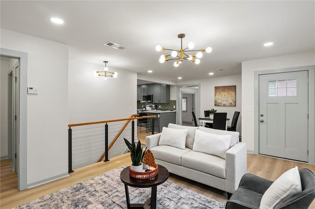 living room featuring light hardwood / wood-style floors and a notable chandelier