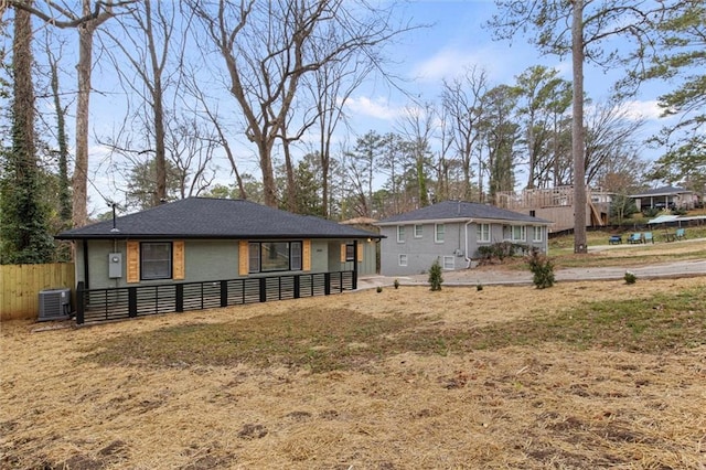 back of property with central AC and a yard