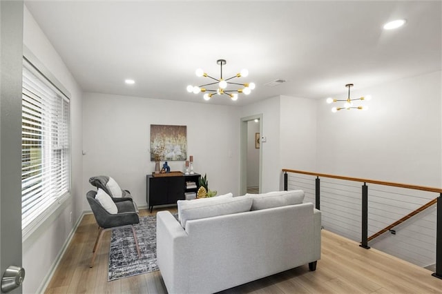 living room featuring an inviting chandelier and light wood-type flooring