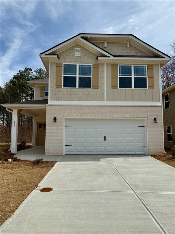 view of front facade with a garage, driveway, and brick siding