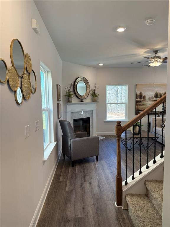 living room with baseboards, dark wood finished floors, stairway, a premium fireplace, and a ceiling fan