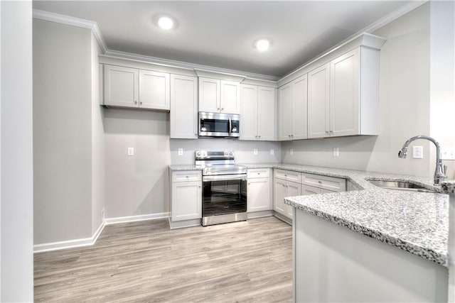 kitchen featuring sink, ornamental molding, appliances with stainless steel finishes, light stone counters, and white cabinetry