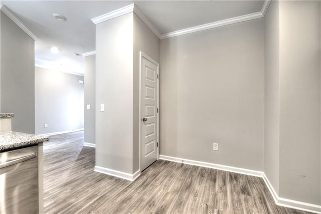 empty room with wood-type flooring and ornamental molding