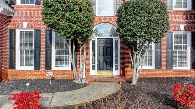 view of exterior entry with brick siding