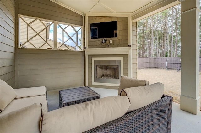 view of patio / terrace featuring fence and an outdoor living space with a fireplace