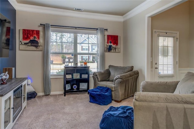 living area with a wealth of natural light, visible vents, crown molding, and carpet flooring