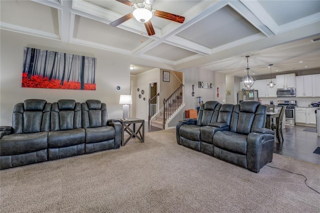 living area featuring stairway, ornamental molding, coffered ceiling, beamed ceiling, and ceiling fan with notable chandelier