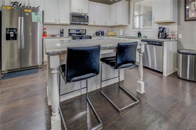 kitchen featuring appliances with stainless steel finishes, dark wood-style flooring, backsplash, and white cabinetry