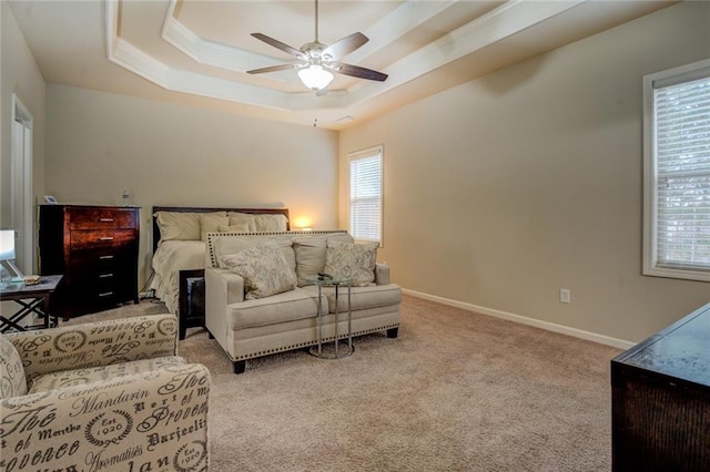 bedroom featuring a ceiling fan, a tray ceiling, baseboards, and carpet