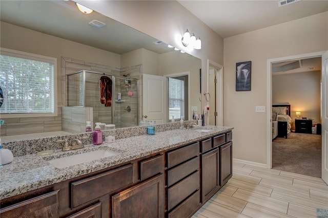 bathroom with double vanity, a stall shower, visible vents, ensuite bathroom, and a sink