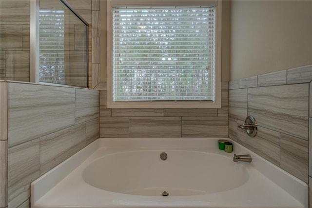 bathroom featuring a wealth of natural light and a bath