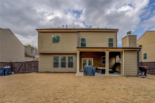 back of house with french doors, a patio, a fenced backyard, a gate, and a yard