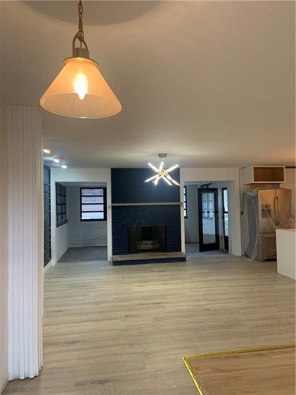 unfurnished living room with a fireplace and light wood-type flooring