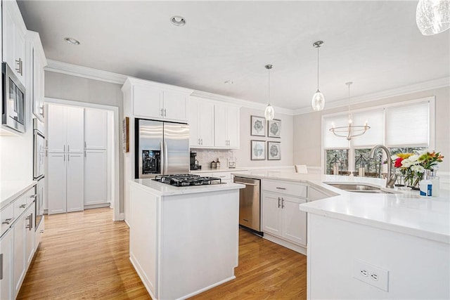 kitchen featuring white cabinetry, stainless steel appliances, sink, and a kitchen island