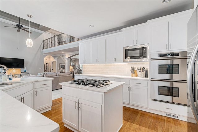 kitchen featuring stainless steel appliances, sink, light hardwood / wood-style flooring, and white cabinets