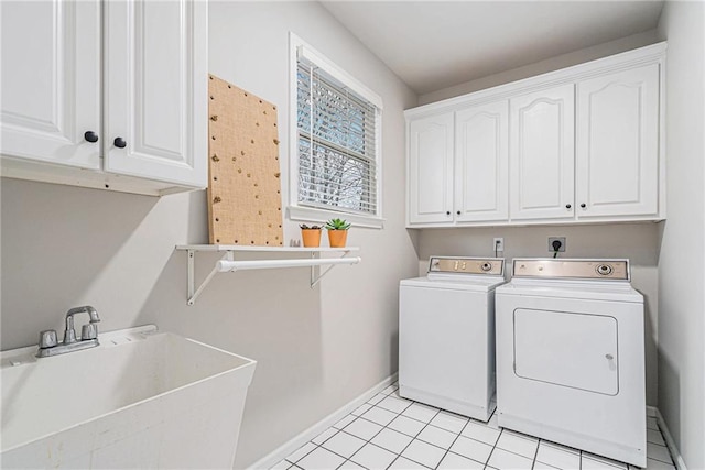 laundry area featuring cabinets, sink, light tile patterned floors, and washing machine and clothes dryer