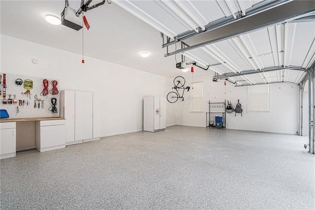 garage with a garage door opener and a workshop area