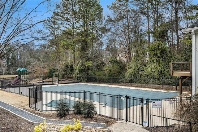 view of swimming pool featuring a patio and a playground