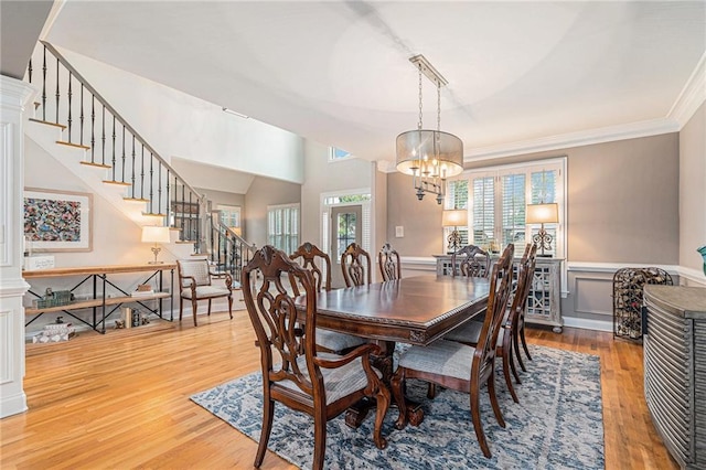 dining room with crown molding, hardwood / wood-style floors, and a notable chandelier