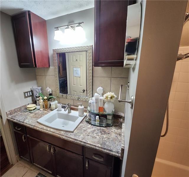 bathroom featuring backsplash, vanity, and tile patterned flooring