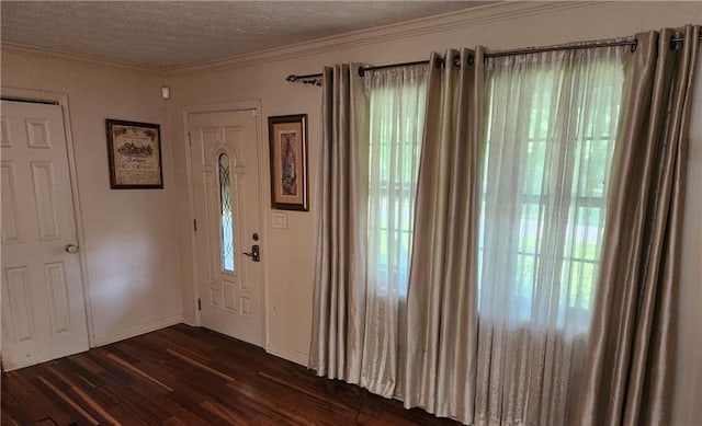 entrance foyer featuring dark wood-style flooring, a textured ceiling, crown molding, and baseboards