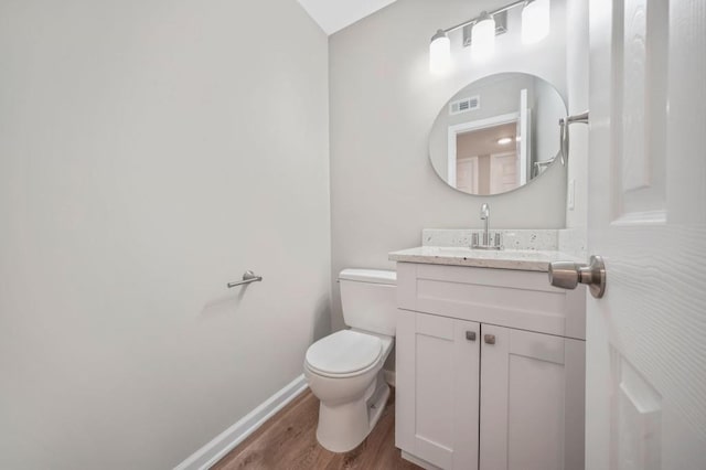 bathroom featuring vanity, wood-type flooring, and toilet