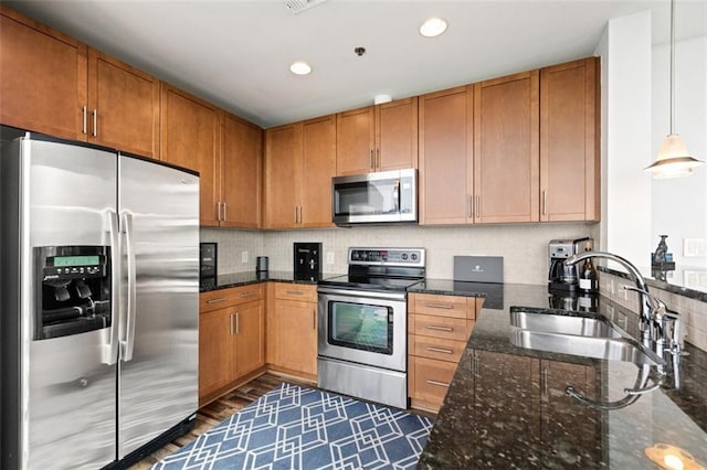 kitchen featuring a sink, brown cabinets, backsplash, and stainless steel appliances