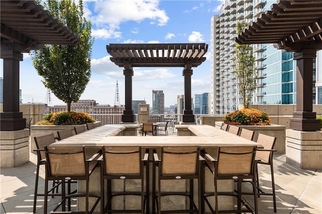 view of patio / terrace with a city view, outdoor dining space, and a pergola