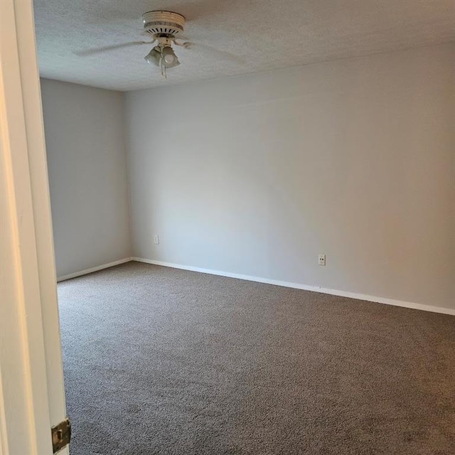 carpeted empty room featuring ceiling fan, baseboards, and a textured ceiling