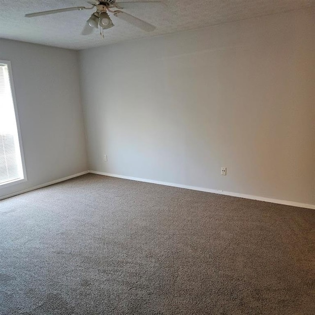 carpeted empty room with ceiling fan, a textured ceiling, and baseboards