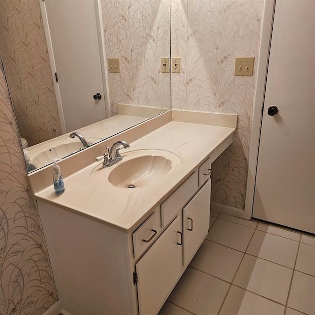 bathroom with baseboards, tile patterned flooring, vanity, and wallpapered walls