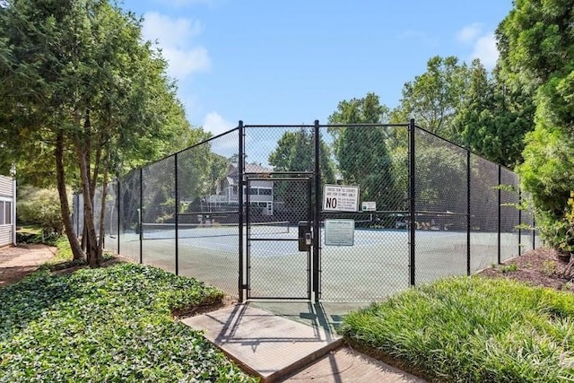 view of tennis court featuring fence and a gate